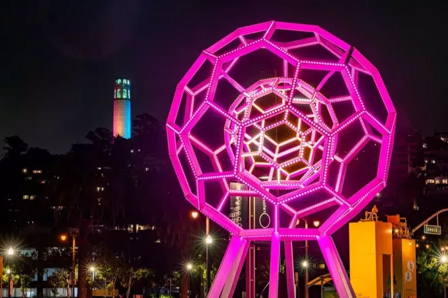 Buckyball leuchtet im Vordergrund, während Coit Tower in der Ferne erstrahlt.